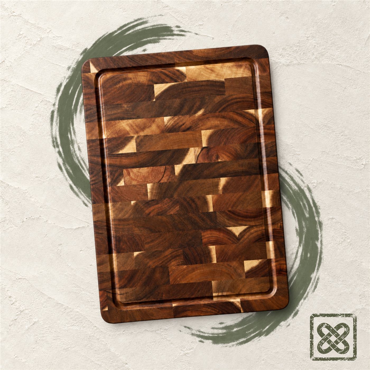 An end-grain acacia cutting board on ivory plaster, a moss-green brush stroke beneath it